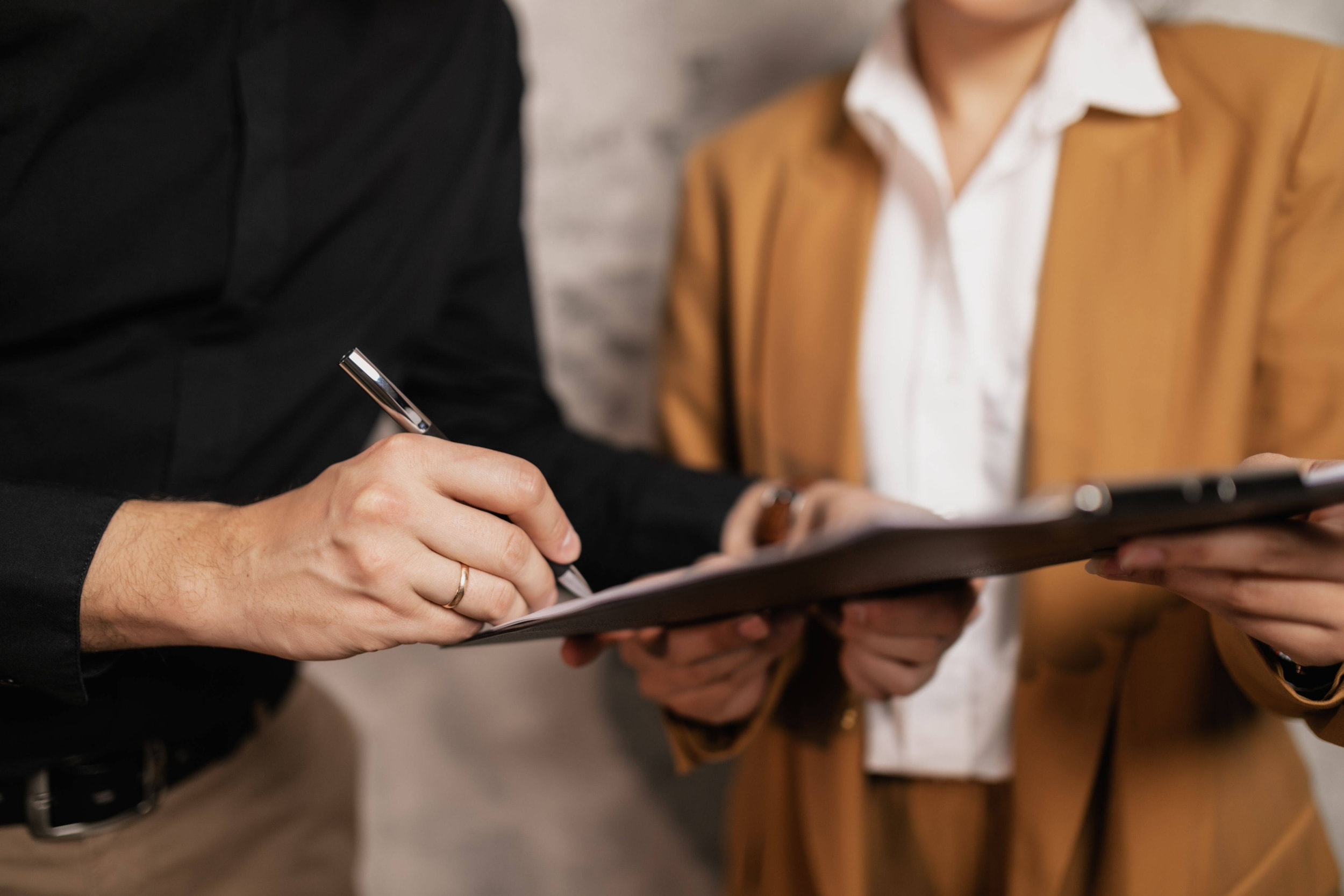 mani che firmano un contratto di lavoro