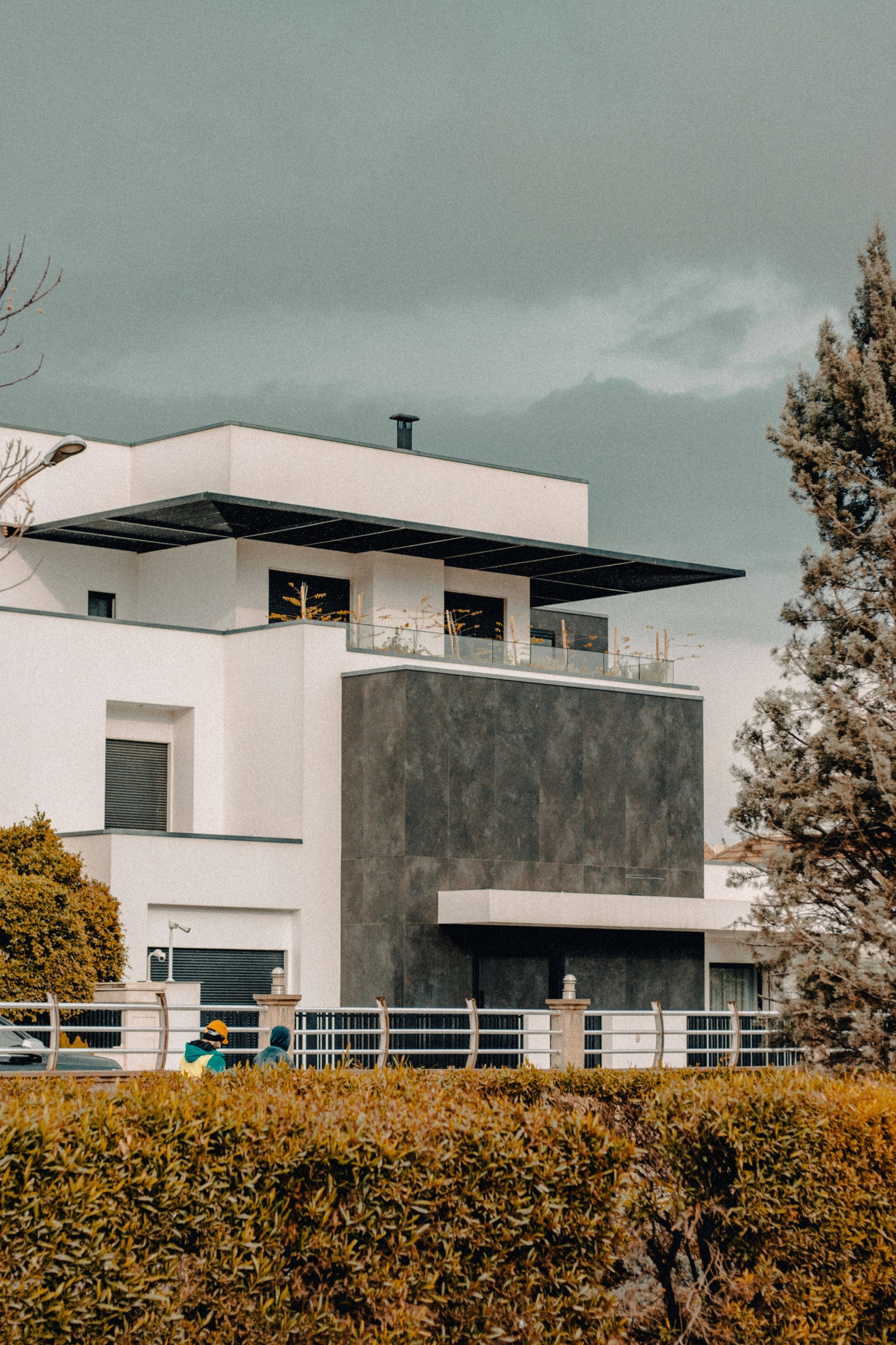 Facciata di casa contemporanea con elementi di design geometrico e paesaggistica.