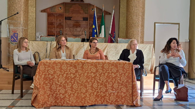 Foto delle relatrici dell'incontro: Silvia Gnagnarella delle Politiche Sociali, la Dirigente Giovanna Sabbarese, l'Assessore Cinzia Amoroso e due rappresentanti della Cooperativa "L'Ancora Sociale" (la Presidente e una mediatrice culturale)