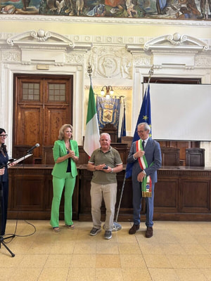 Foto del momento della consegna della medaglia a Alfredo Sigismondi, congiunto di Renato,. A destra, il Sindaco Paolini e a sinistra di Sigismondi il Prefetto D'Agostino.