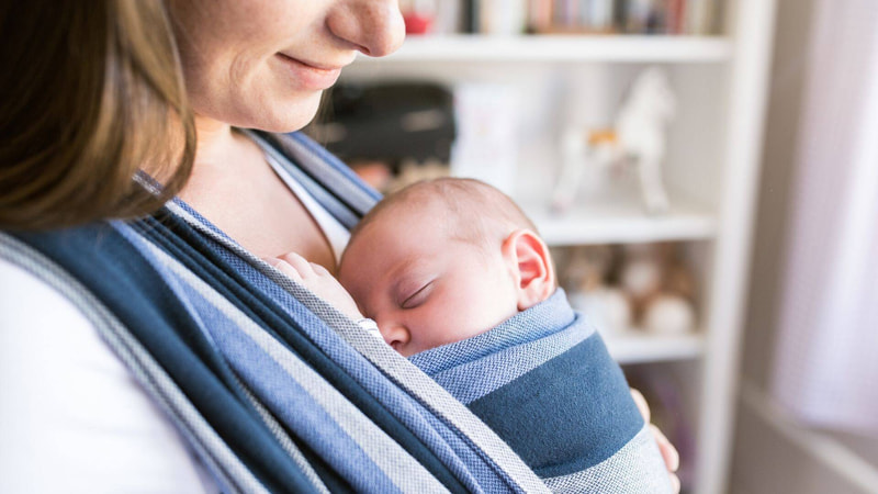 Foto di mamma con bambino in fascia 