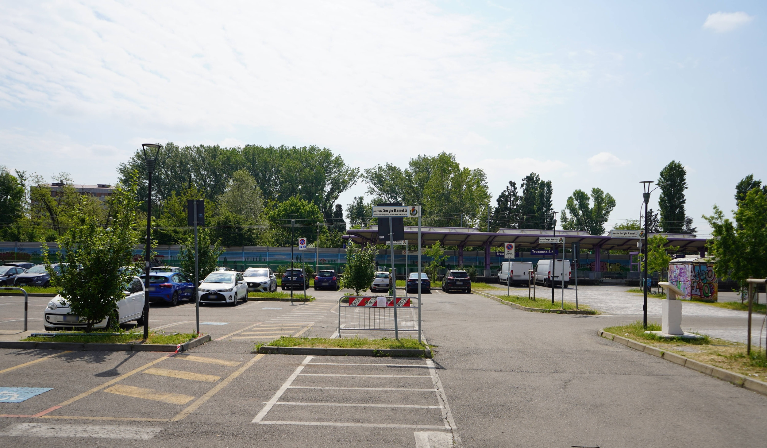 Parcheggio a raso Stazione ferroviaria, con segnaletica e auto parcheggiate